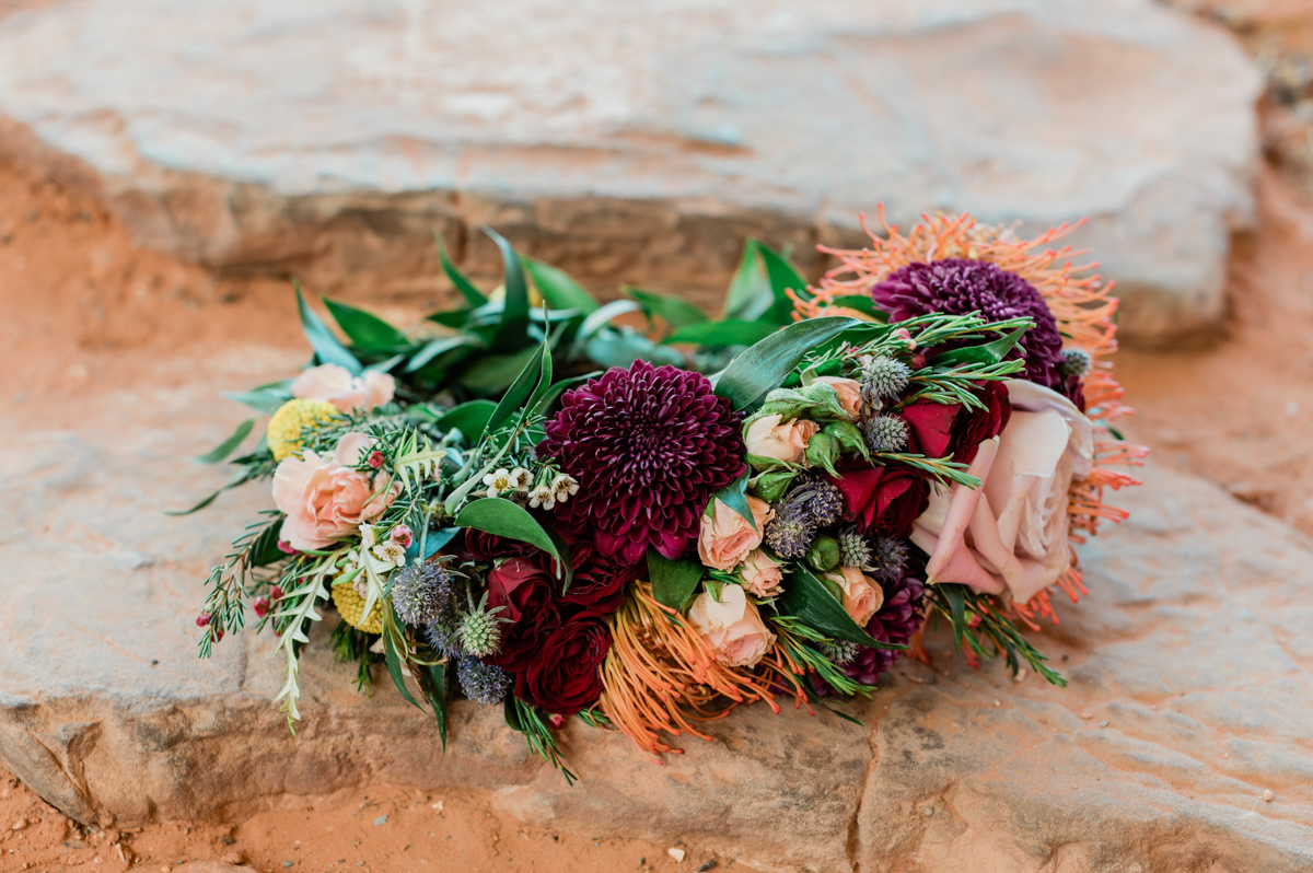 Colorful bridal bouquet laid on the rocks.