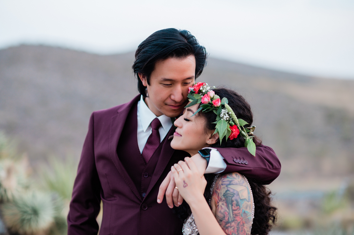 Bride and groom embrace during an outdoor wedding.