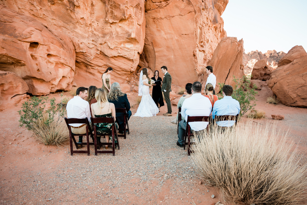 Guests watching a wedding ceremony outside in the Las Vegas desert.
