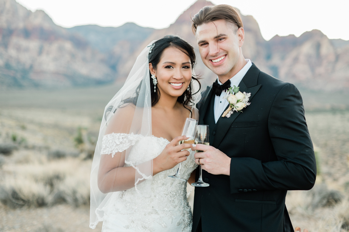 Happy wedding couple toasting with champagne glasses.