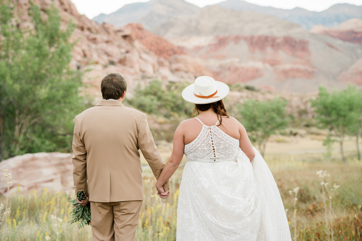Bride and groom holding hands after their wedding in the desert.