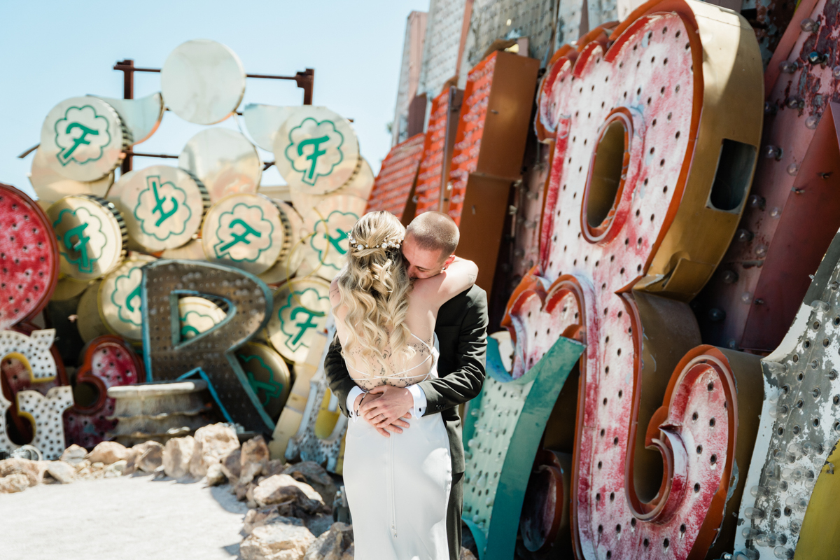 Newlyweds embracing at wedding in the Neon Museum in Las Vegas.