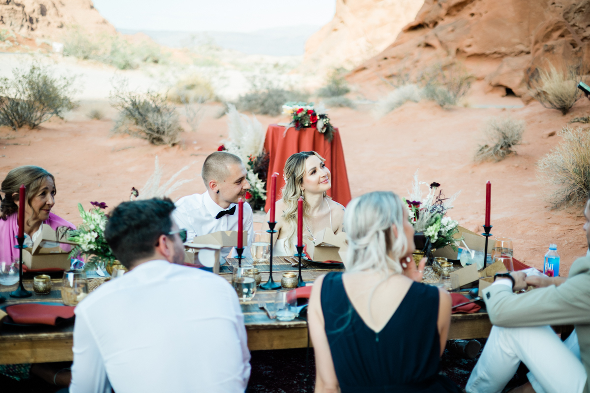 Newlyweds sitting with the guests at a reception in the Valley of Fire State Park.