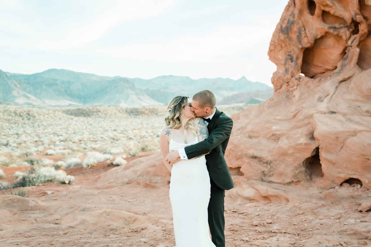 Newlyweds embracing after wedding ceremony in Mojave Desert.