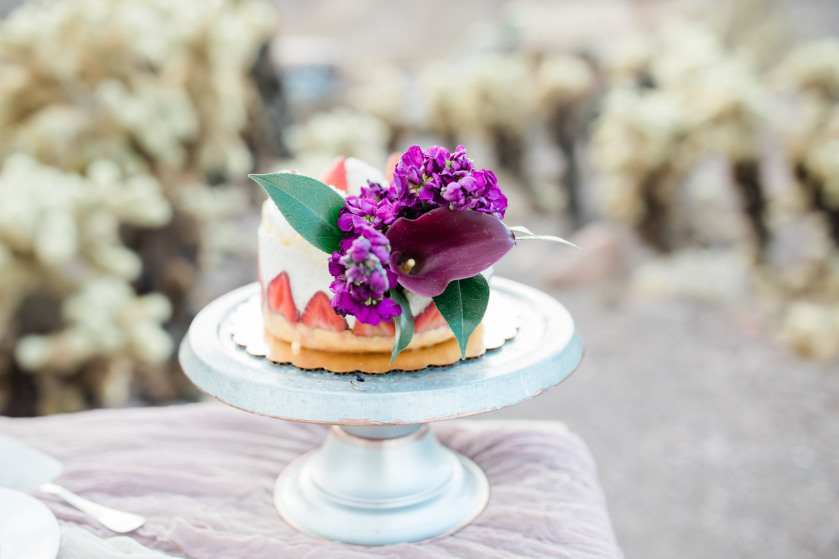 Wedding cake decorated with purple flowers.