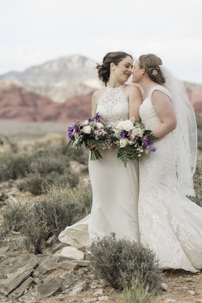 Two brides sharing a romantic moment while getting married in the desert of Las Vegas.