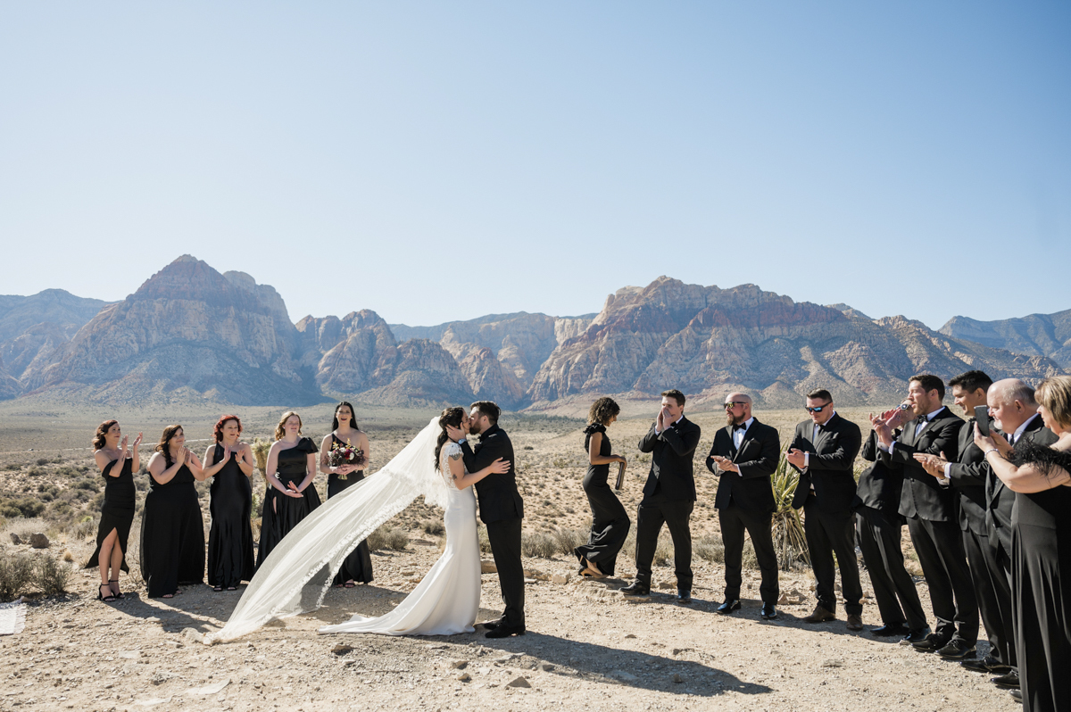 Bride and groom kissing while getting married in Las Vegas desert.