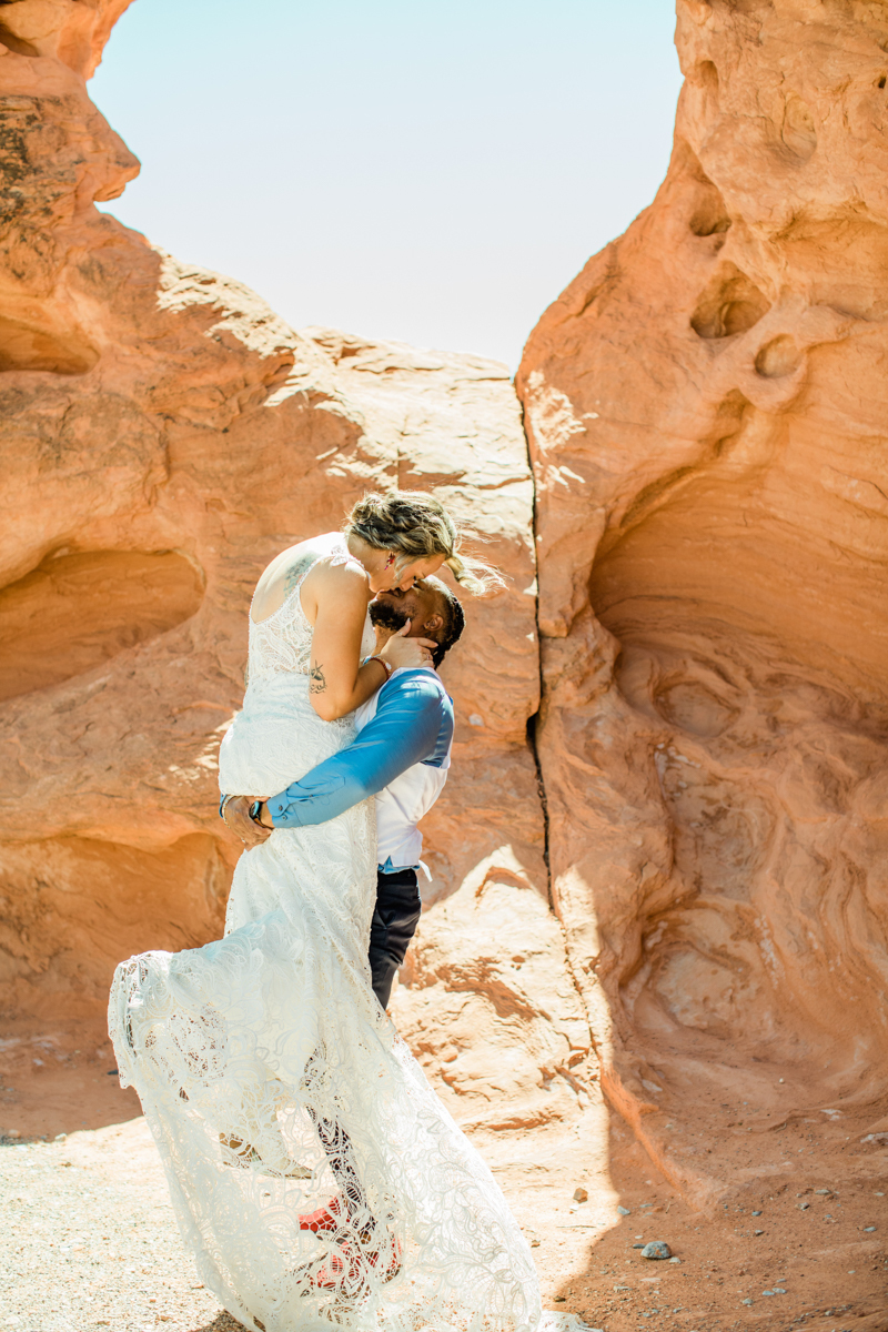Groom holding his bride in the air while kissing.