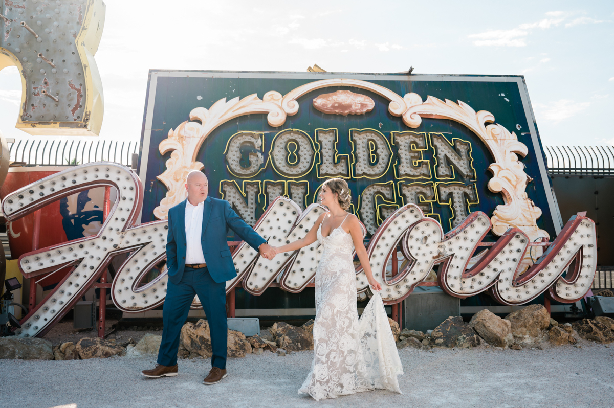 Bride and groom walking through the Neon Museum in Las Vegas for their wedding.