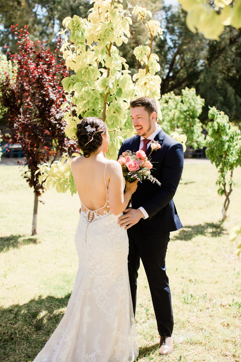 Bride and groom dancing in a fruit orchard.