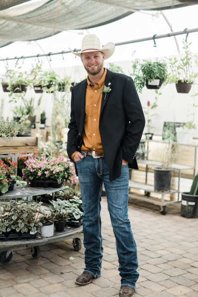 A groom in a cowboy hat, boots, jeans and a black sport coat poses amongst plants on display at Cactus Joe’s. A groom in a cowboy hat, boots, jeans and a black sport coat poses amongst plants on display at Cactus Joe’s.