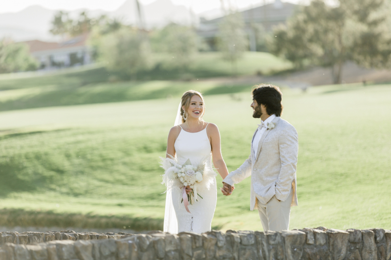 Bride and groom walking along stone path at Canyon Gate Country Club.