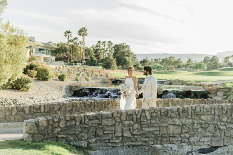 Bride and groom walking along stone path at Canyon Gate Country Club.