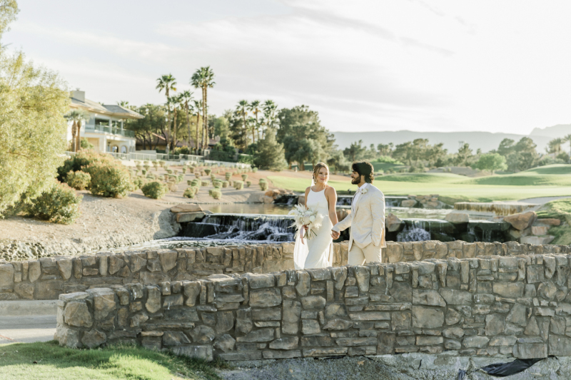 Bride and groom walking along stone path at Canyon Gate Country Club.