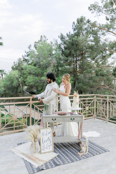 Bride and groom popping celebration champagne.