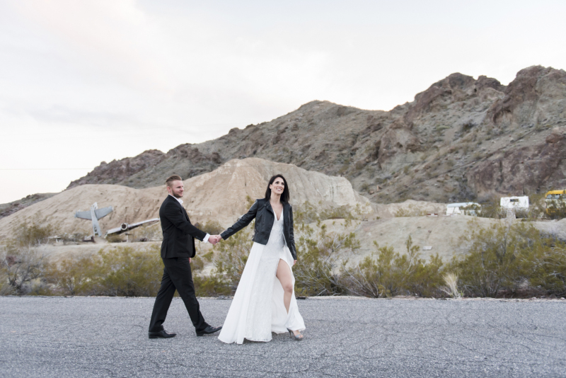 A bride leads her groom down the street in Eldorado Canyon as they celebrate their Las Vegas destination wedding.