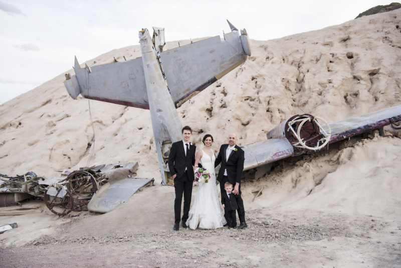 A bride and members of her family pose for a portrait in front of an airplane on display in Eldorado Canyon.