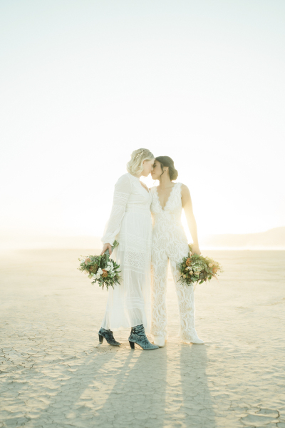 Female couple standing with foreheads touching.