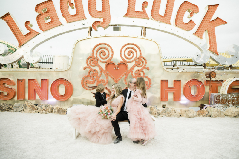 The retired neon sign from the Lady Luck Hotel and Casino acts as a backdrop for wedding day photos of a couple, their son and their daughter at the Neon Museum in Las Vegas.