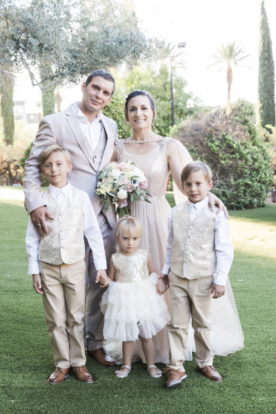 A husband and wife who have renewed their wedding vows are posing for a family picture with three children in a garden at Green Valley Ranch in Las Vegas.