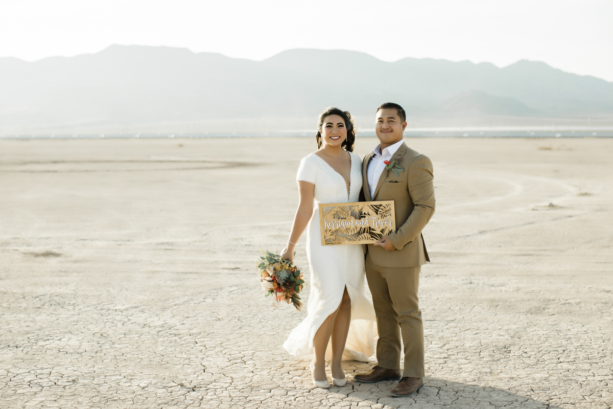 Couple holding personalized name sign.