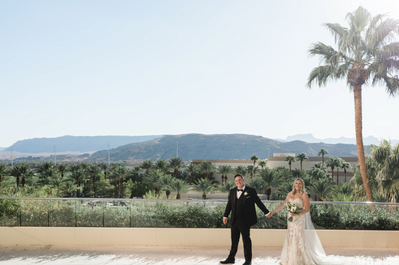 Emily + Landon holding hands in front a beautiful mountain view.