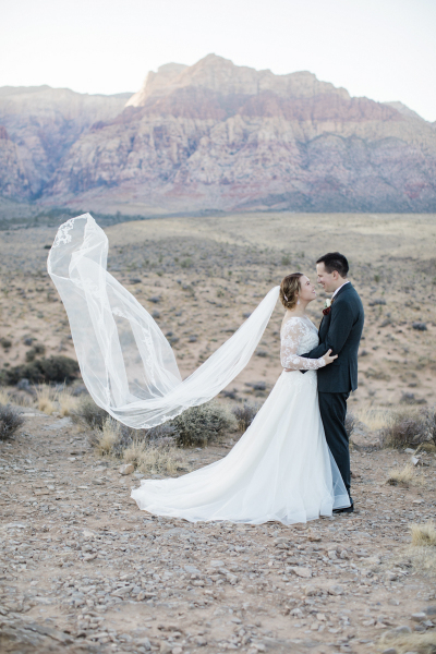 Brides veil caught in the wind with mountain landscape as the background.