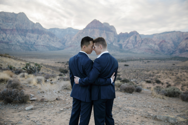 Couple touching foreheads with Red Rock Canyon Overlook landscape in the background.