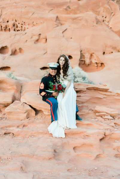 Bride sitting on military groom's knee.