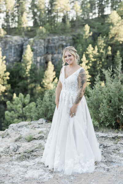 A young bride poses for a wedding portrait amongst the pine trees and rocky cliffs of the Black Hills of South Dakota.