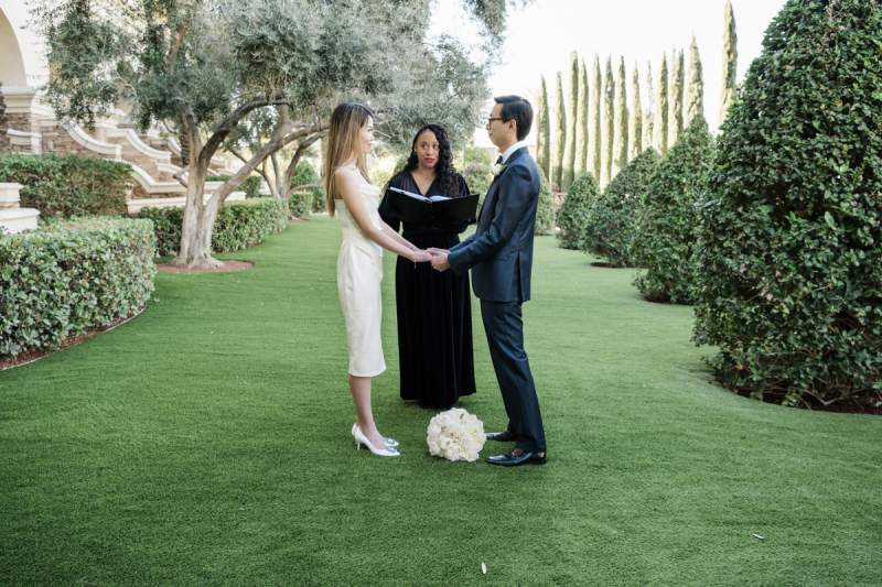 A bride and groom are married by a wedding officiant in a garden at Green Valley Ranch in Las Vegas.