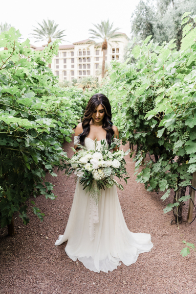 Bride looking down at wedding floral bouquet.