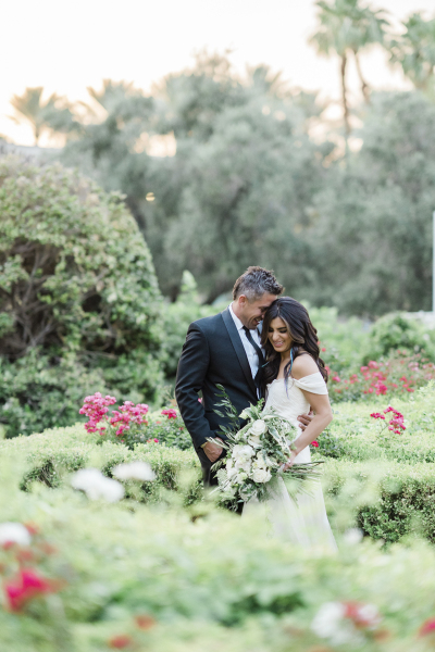 Newlywed couple in flower garden.