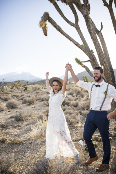 Newlywed couple with arms in the air.