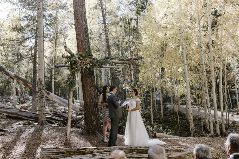 Golden aspen leaves create the background for a wedding ceremony taking place outdoors in the mountains at Lee Canyon near Las Vegas.