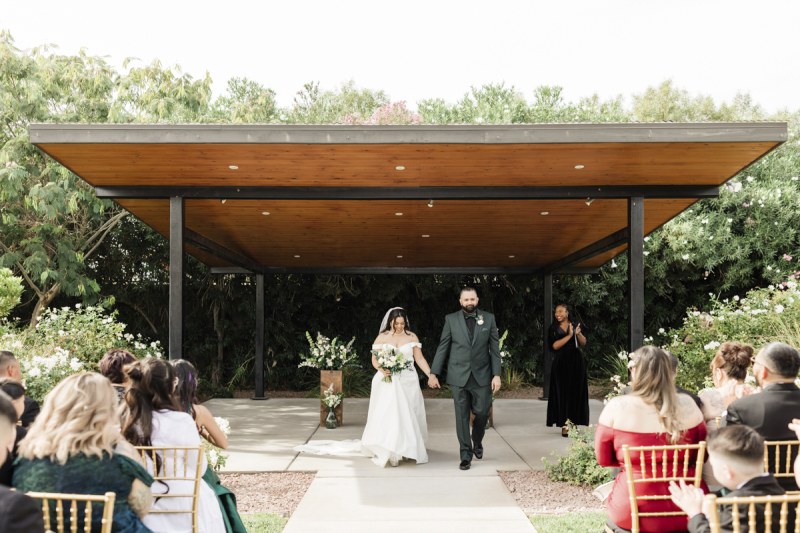 At the conclusion of their wedding ceremony, a bride and groom walk towards their seated wedding guests.