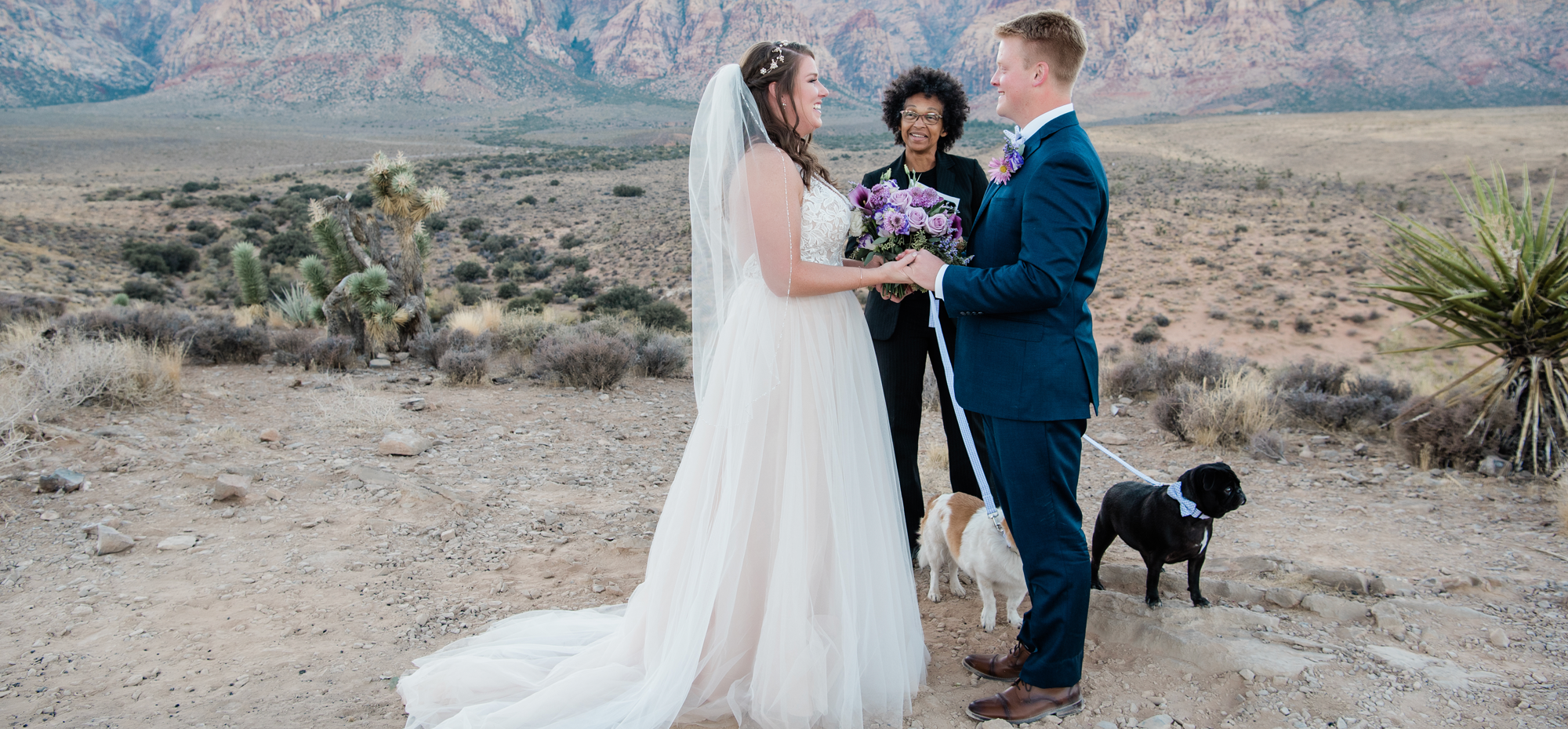 Bride and groom at their destination wedding ceremony with their pet dog at their side.