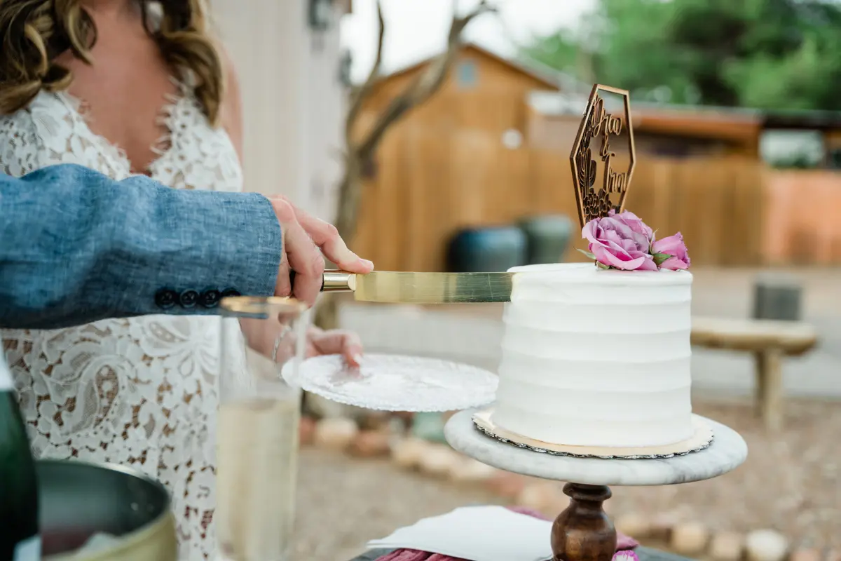 a couple cuts a small wedding cake together.