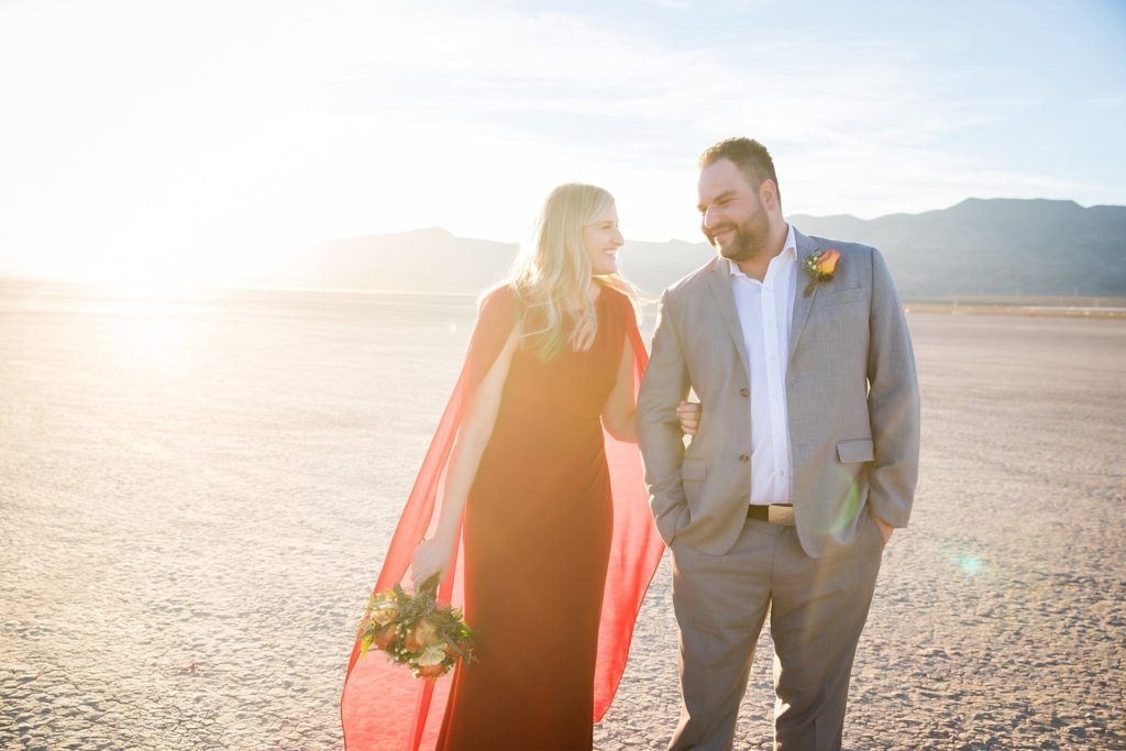 Groom and bride walking arm in arm at their outdoor wedding in the Las Vegas desert.