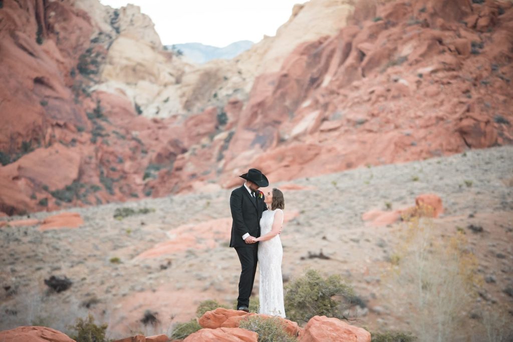 Groom and bride holding hands during wedding in the Red Rock Canyon.