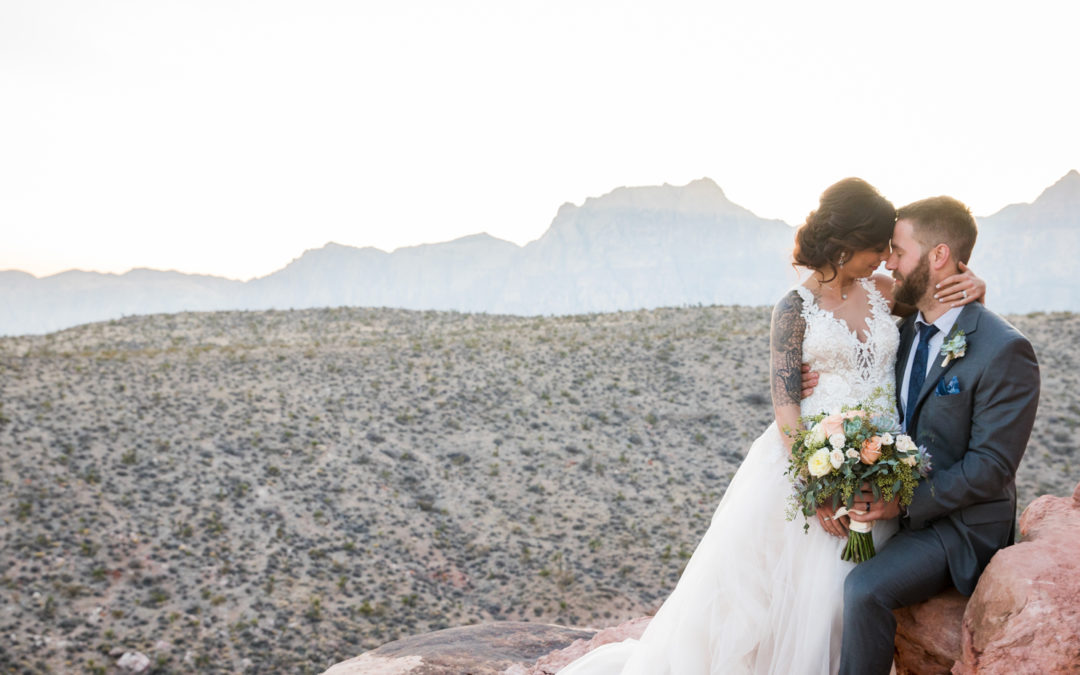 Wedding couple sitting on a rock in the desert.