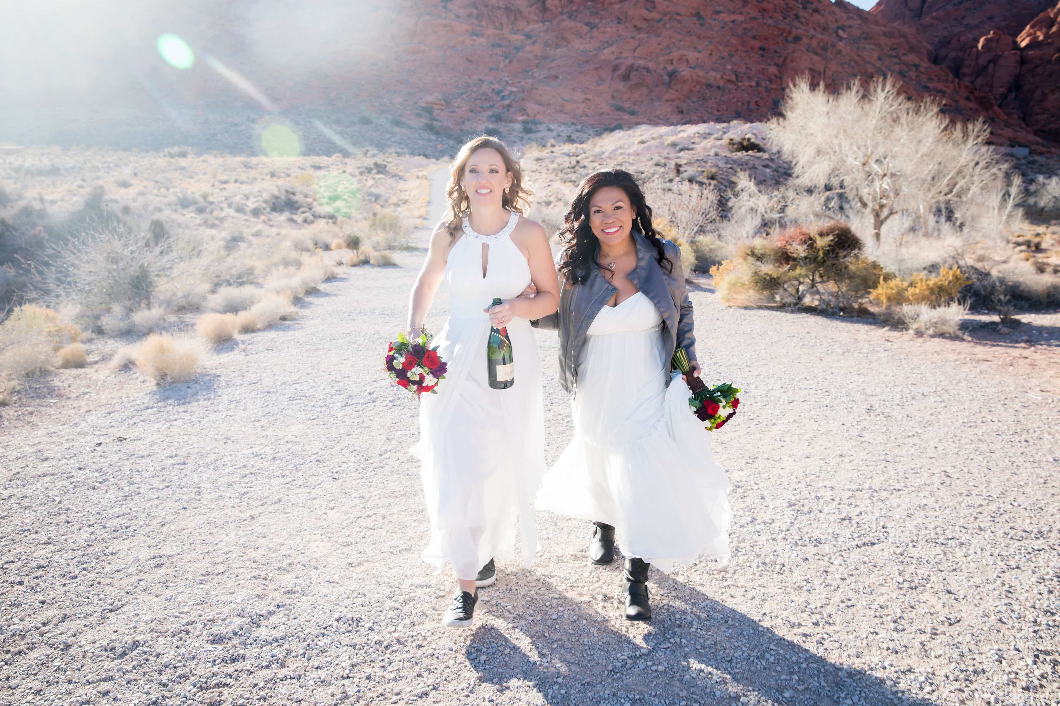 Jaime and Jannet walk together with champagne and flowers.