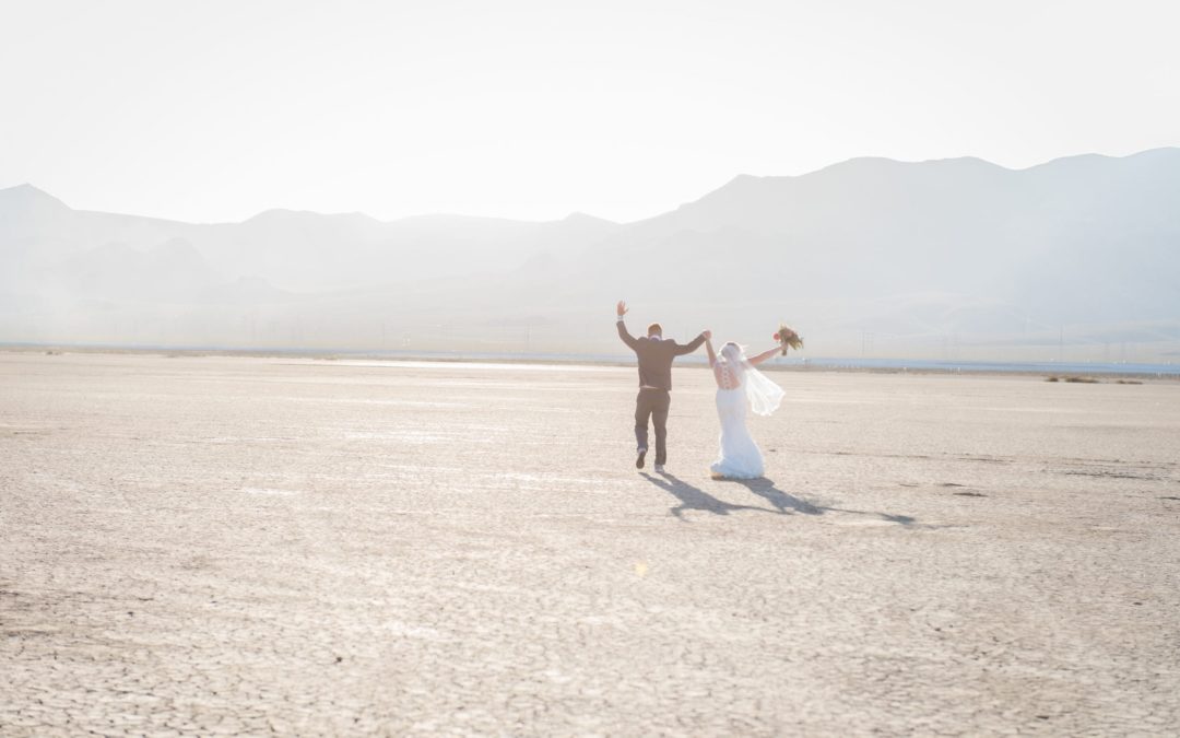 Newlywed couple celebrating in dry lake bed in Las Vegas.
