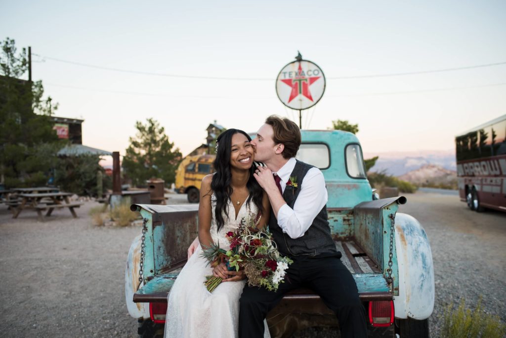 Bride and groom sitting in the back of an old truck at Eldorado Canyon.