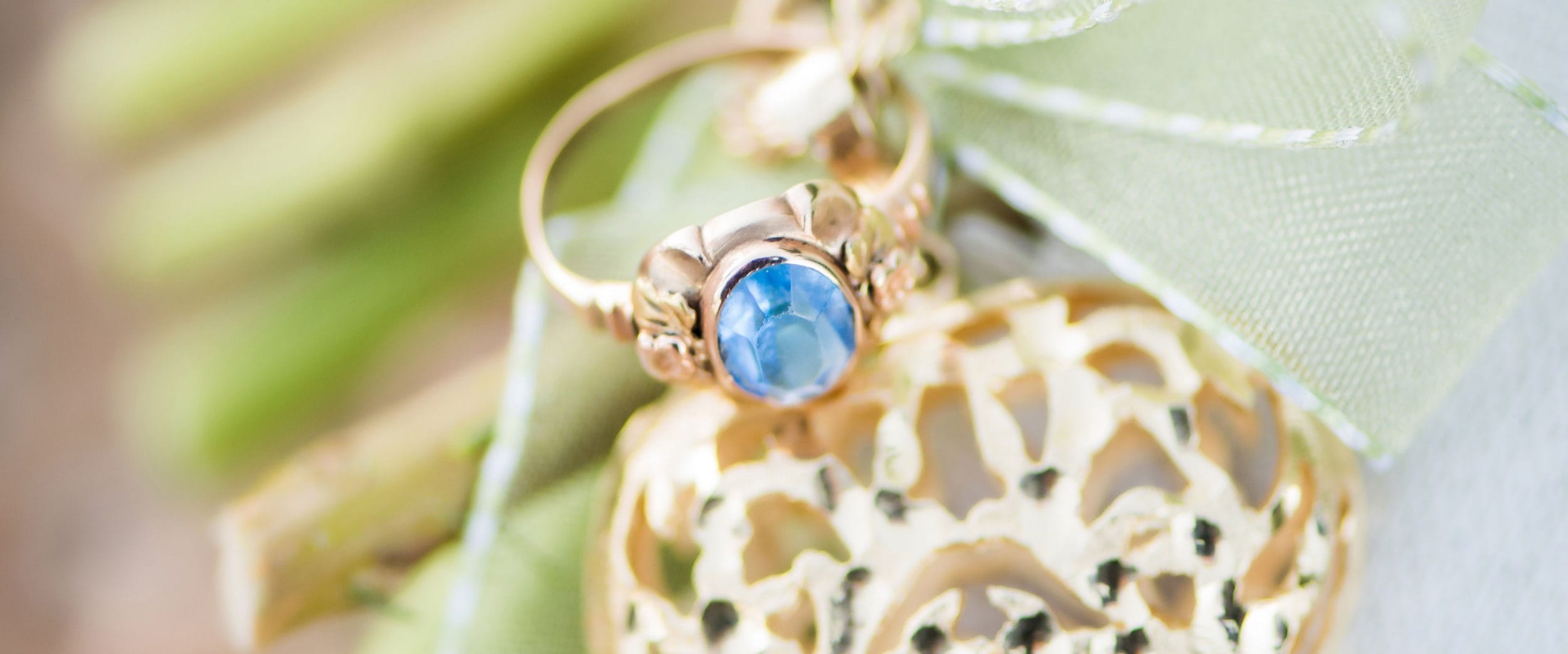 A photo of a blue gem in a gold ring setting.