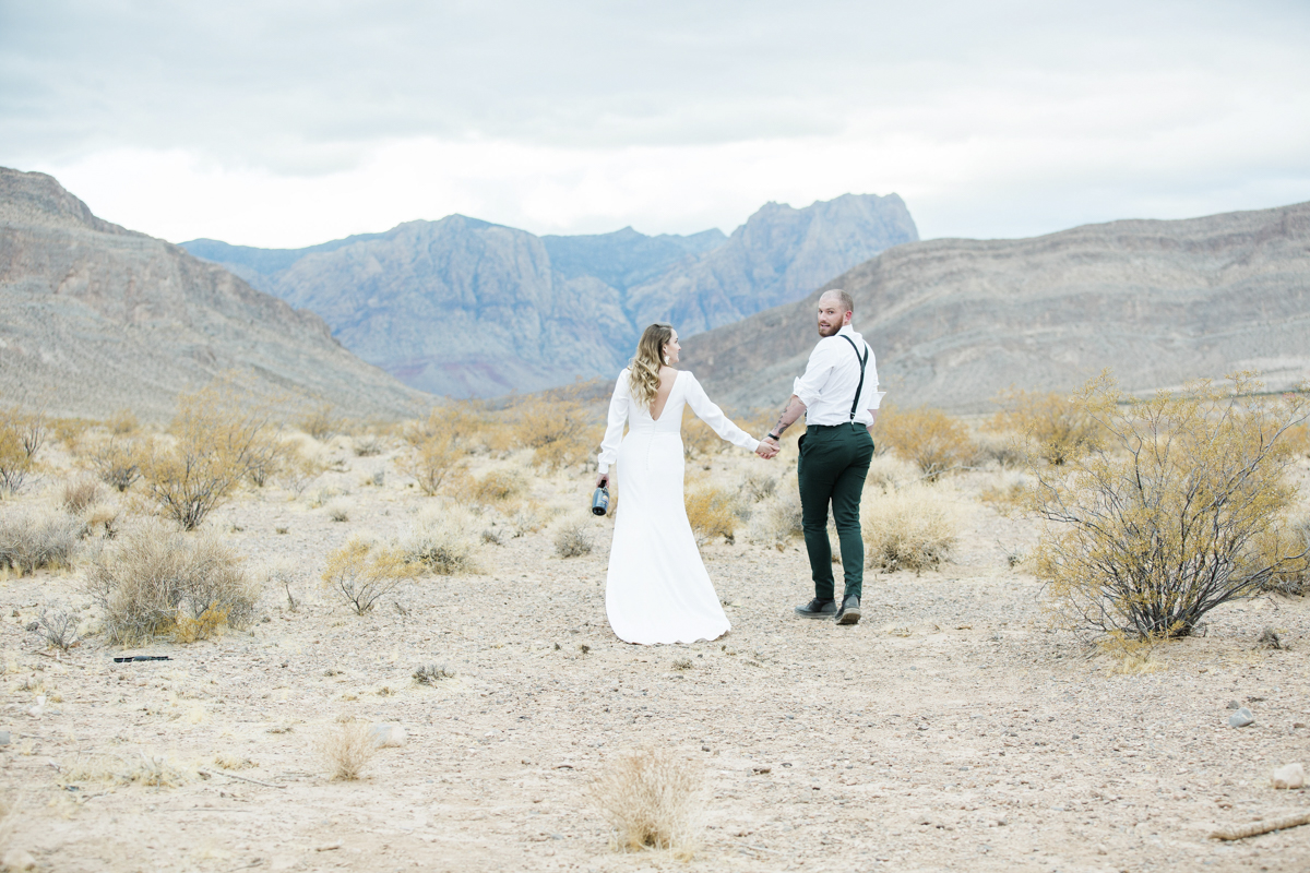 Couple walking hand in hand in the desert