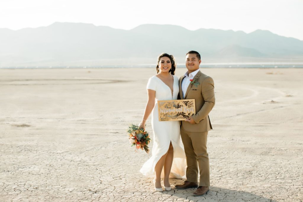 Kerrigan and Trevor at the Dry Lake Bed with wooden sign.