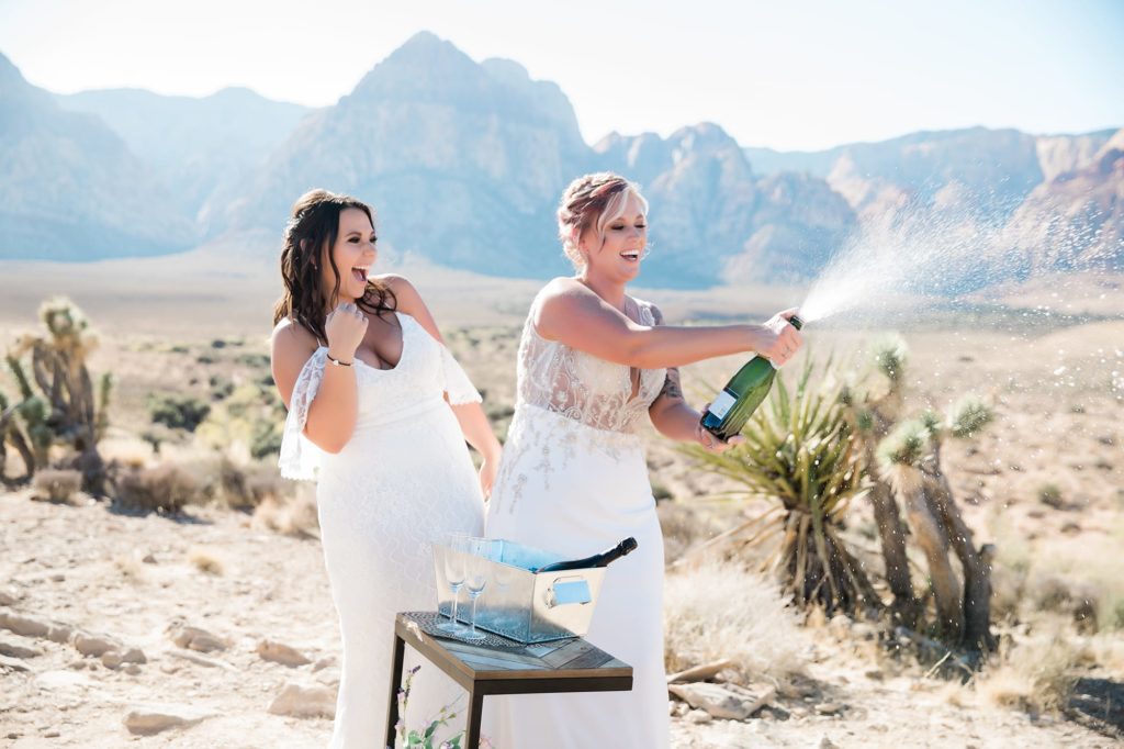 Two brides with champagne during an outdoor minimony ceremony in Las Vegas.