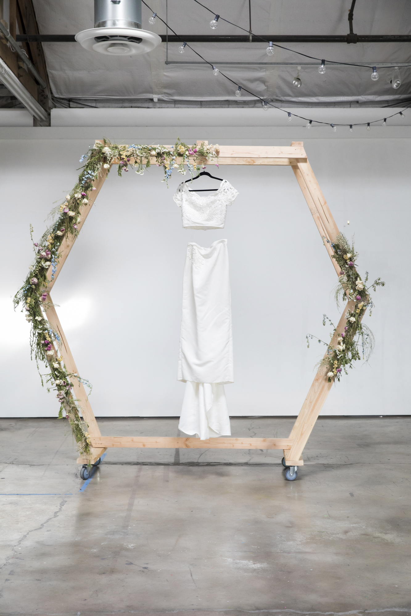 White eco-friendly wedding dress hanging on wooden stand