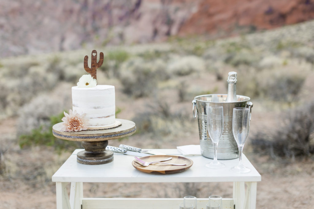 Wedding cake and champagne on wooden cart